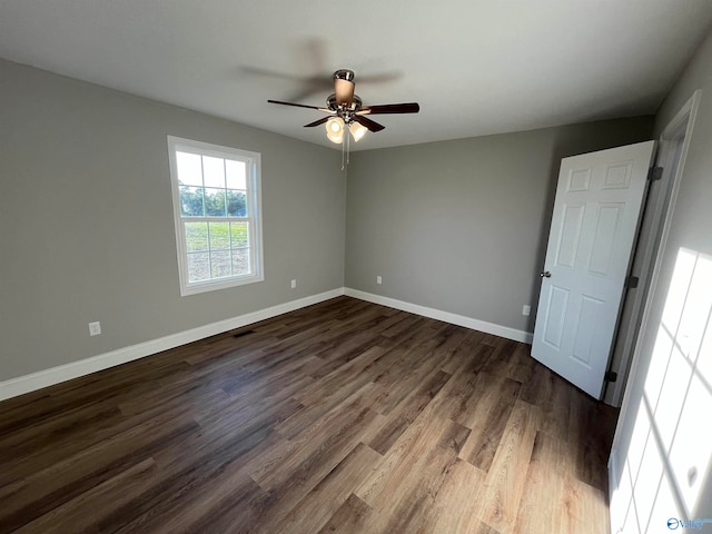 spare room with dark wood-type flooring and ceiling fan