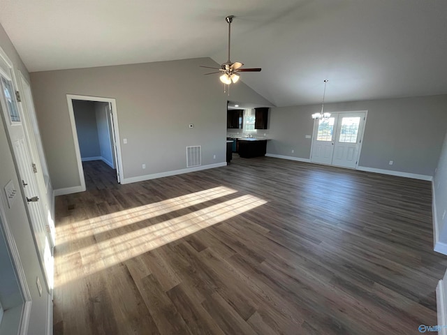 unfurnished living room with ceiling fan with notable chandelier, vaulted ceiling, and dark hardwood / wood-style flooring