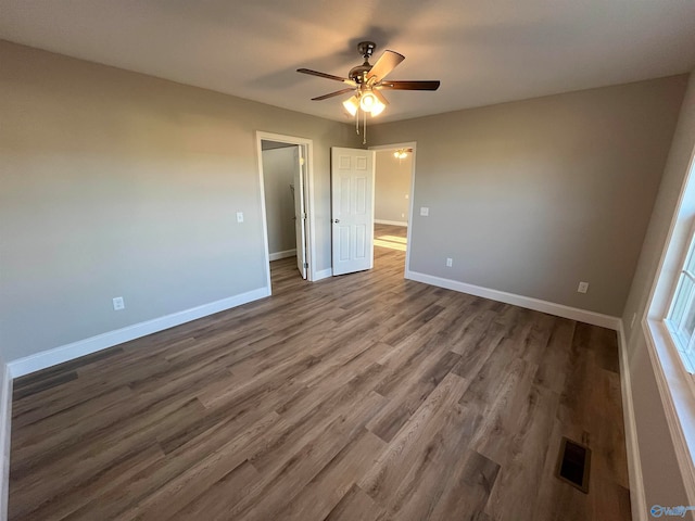 unfurnished bedroom featuring dark hardwood / wood-style floors and ceiling fan