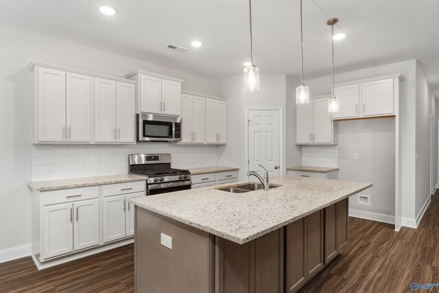 kitchen with stainless steel appliances, dark hardwood / wood-style floors, pendant lighting, a center island with sink, and custom range hood