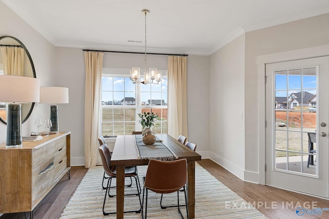 dining space featuring a chandelier, dark hardwood / wood-style floors, and a healthy amount of sunlight