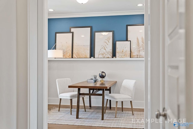 dining area with hardwood / wood-style floors and crown molding