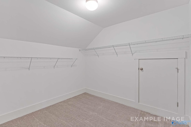 walk in closet with carpet and vaulted ceiling