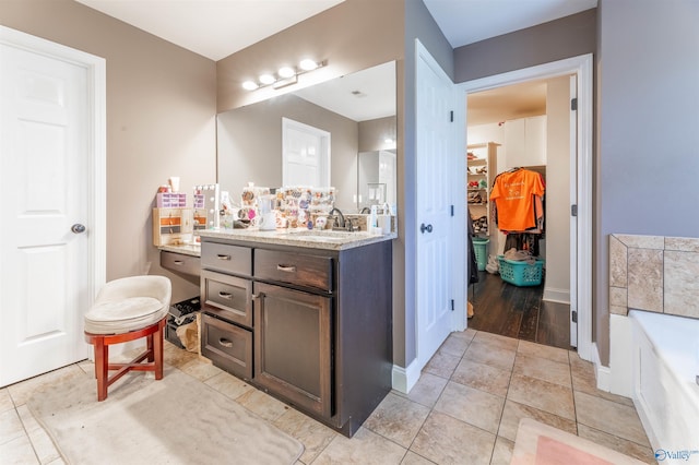 4198 Pilgrims Rest Rd, Southside, AL 35907 - bathroom featuring vanity, a walk in closet, a tub to relax in, and baseboards