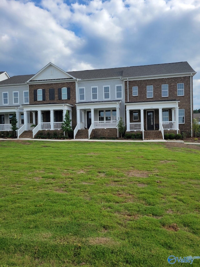 view of property with covered porch and a front lawn