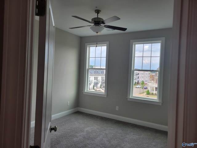 empty room with carpet flooring, a wealth of natural light, and ceiling fan