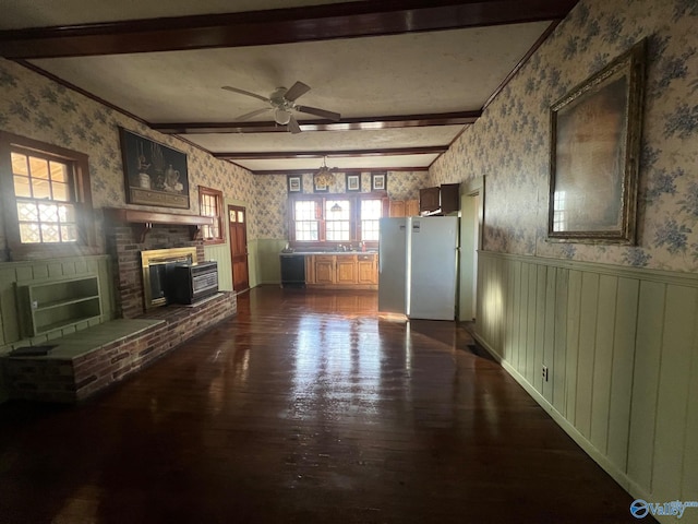 unfurnished living room featuring a fireplace, beam ceiling, hardwood / wood-style flooring, and ceiling fan