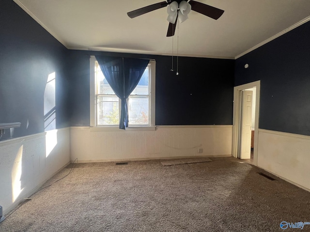 carpeted empty room with ceiling fan and ornamental molding