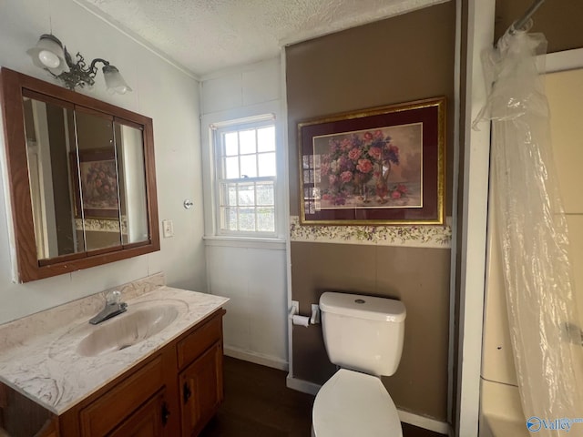 bathroom with hardwood / wood-style floors, vanity, toilet, and a textured ceiling