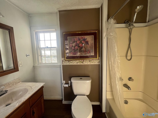 full bathroom featuring vanity, hardwood / wood-style flooring, toilet, a textured ceiling, and shower / tub combo with curtain