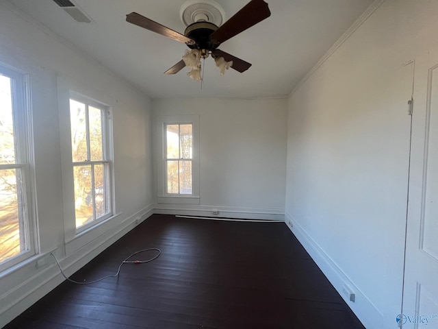 empty room with ceiling fan, dark hardwood / wood-style floors, and ornamental molding