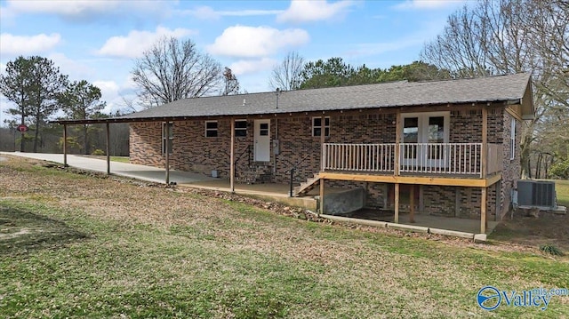 back of house featuring a wooden deck, a lawn, a patio area, and central air condition unit