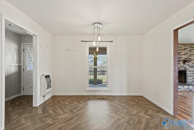 unfurnished dining area featuring heating unit and dark parquet floors