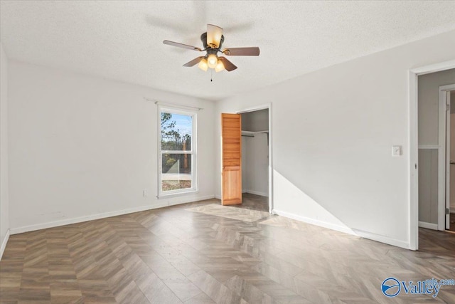 unfurnished bedroom featuring ceiling fan, parquet floors, a textured ceiling, and a closet