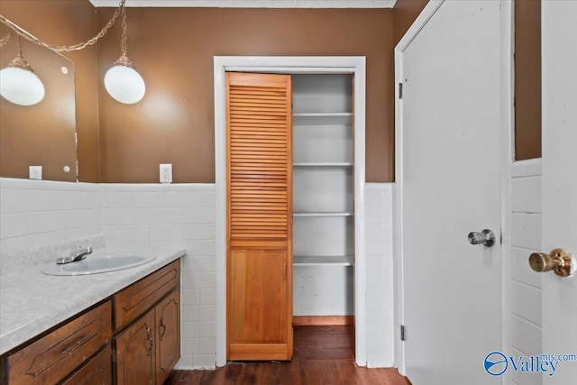 bathroom featuring hardwood / wood-style flooring, vanity, and tile walls