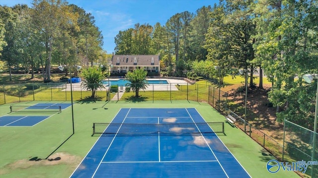 view of tennis court featuring a fenced in pool