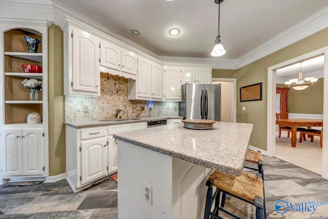 kitchen with a kitchen island, stainless steel appliances, white cabinets, sink, and crown molding