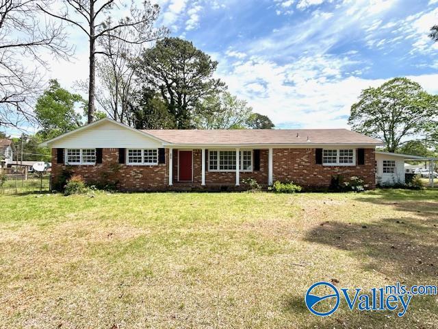 single story home featuring brick siding and a front lawn