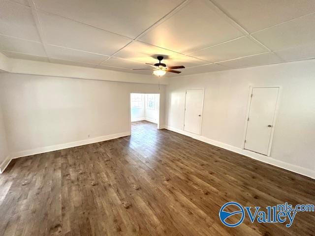 spare room with ceiling fan, dark wood finished floors, and baseboards