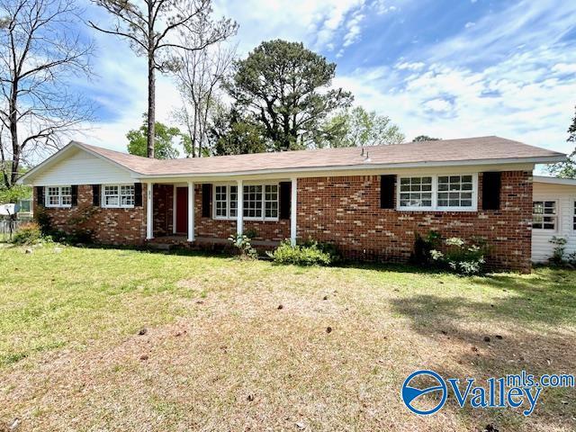 single story home featuring a front lawn and brick siding