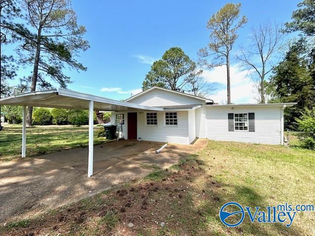 view of front of house with a carport and a front lawn