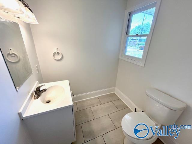 bathroom with tile patterned floors, vanity, toilet, and baseboards