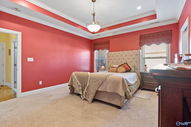 bedroom featuring visible vents, light carpet, a tray ceiling, crown molding, and baseboards