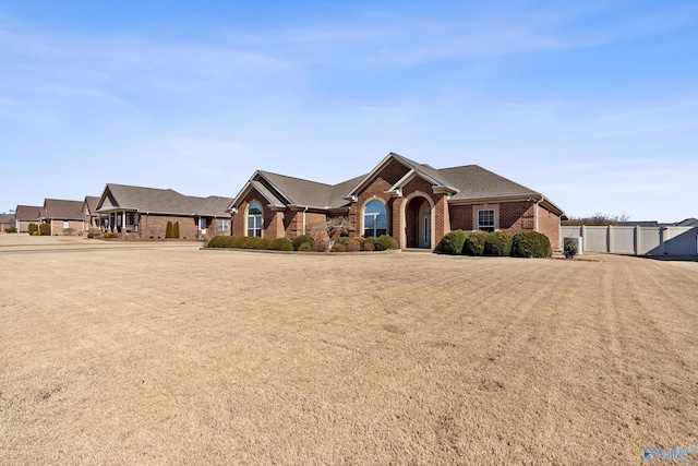 view of front of house with fence and brick siding