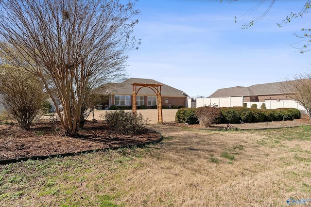 view of front facade with fence, a front yard, and a pergola