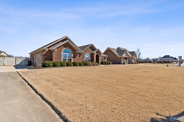 view of front of house featuring brick siding, fence, and a gate