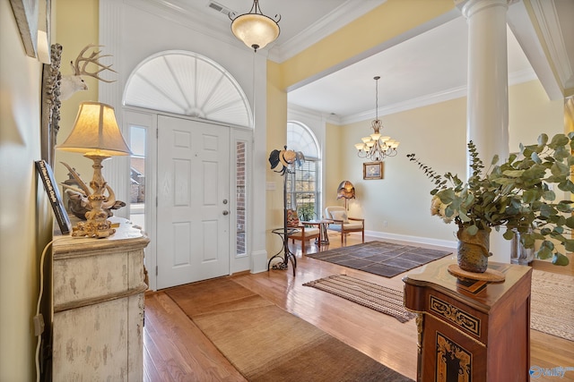 foyer with visible vents, crown molding, baseboards, and wood finished floors