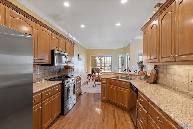 kitchen with crown molding, light wood-type flooring, brown cabinets, stainless steel appliances, and a sink