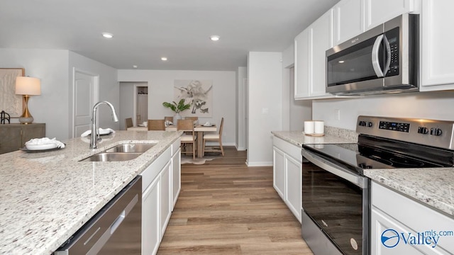 18876 Wicklow Cir, Athens, AL 35613 - kitchen featuring sink, light stone counters, white cabinetry, appliances with stainless steel finishes, and light hardwood / wood-style floors