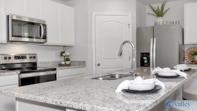 18876 Wicklow Cir, Athens, AL 35613 - kitchen featuring white cabinetry, appliances with stainless steel finishes, a kitchen island with sink, and sink