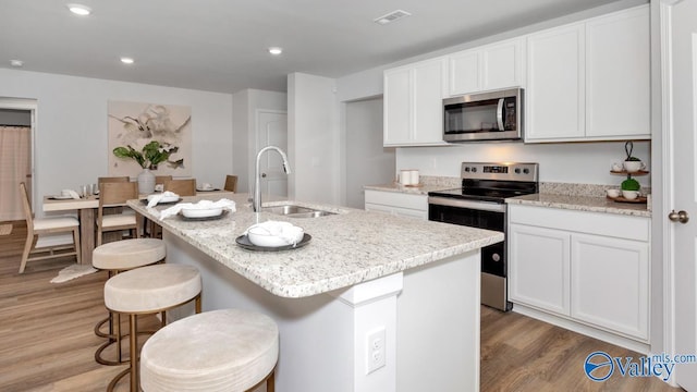 18876 Wicklow Cir, Athens, AL 35613 - kitchen featuring a kitchen island with sink, sink, stainless steel appliances, and white cabinets