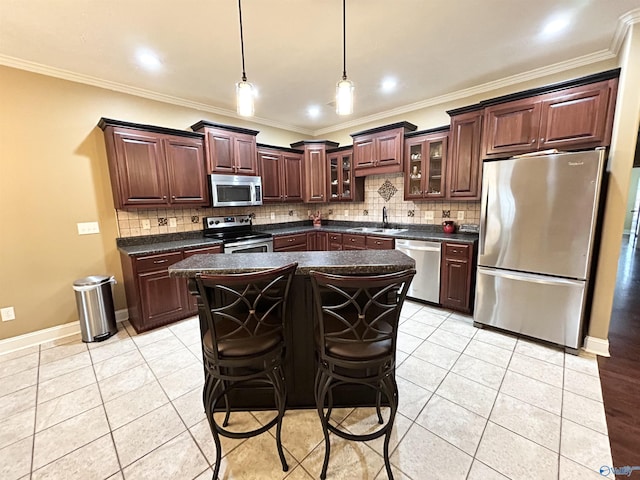 kitchen with a kitchen island, appliances with stainless steel finishes, sink, a breakfast bar area, and dark brown cabinetry