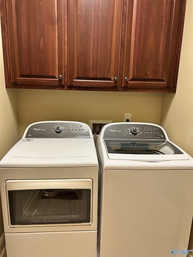 washroom featuring cabinets and independent washer and dryer