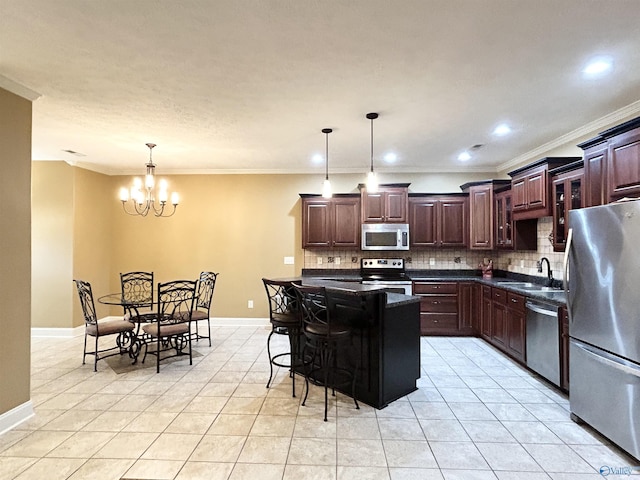 kitchen featuring sink, decorative light fixtures, a kitchen breakfast bar, a kitchen island, and stainless steel appliances