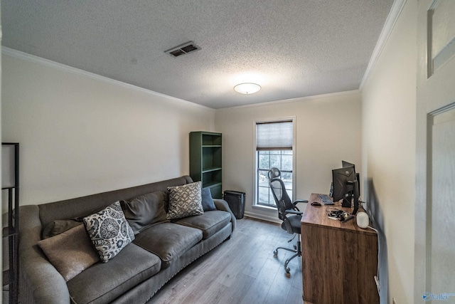 home office with crown molding, light hardwood / wood-style flooring, and a textured ceiling