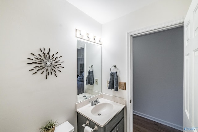 bathroom featuring vanity, hardwood / wood-style floors, and toilet