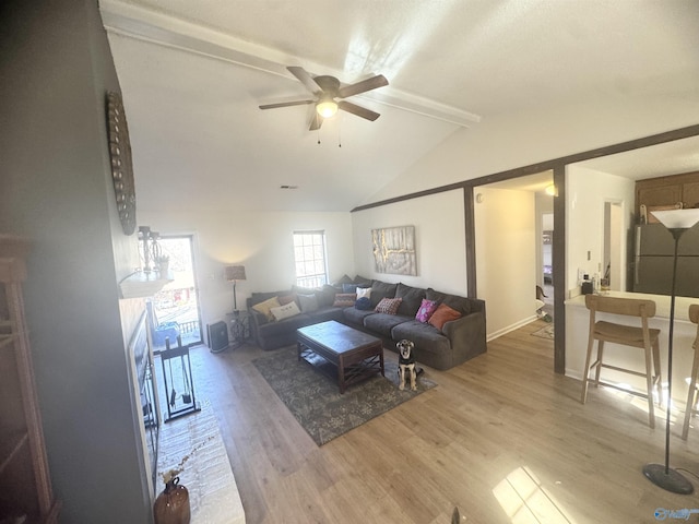 living room featuring hardwood / wood-style flooring, ceiling fan, and lofted ceiling with beams