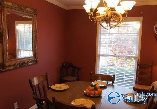 dining area featuring crown molding and a notable chandelier