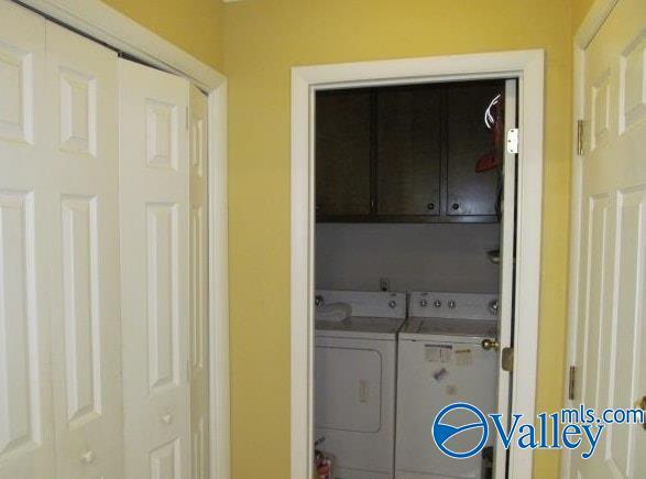 washroom with cabinets and washing machine and dryer