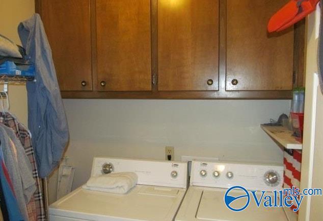 washroom featuring cabinets and washer and clothes dryer