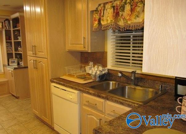 kitchen featuring white dishwasher, sink, and light brown cabinetry