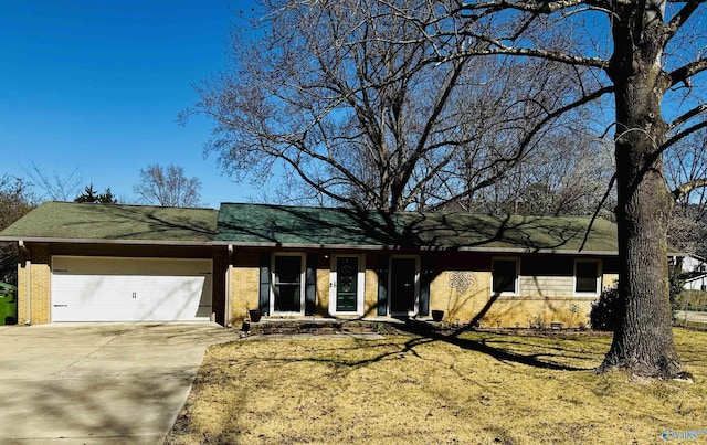 ranch-style home with concrete driveway, an attached garage, brick siding, and a shingled roof