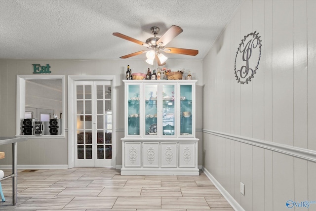 unfurnished dining area featuring a ceiling fan and a textured ceiling