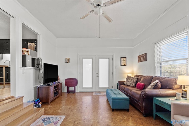 living area with a ceiling fan, tile patterned floors, french doors, and ornamental molding