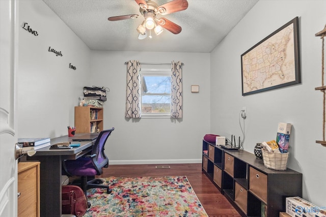 office space with a ceiling fan, baseboards, a textured ceiling, and dark wood-style flooring