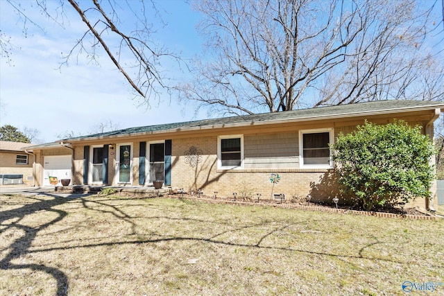 view of front of property featuring brick siding, a garage, and a front yard